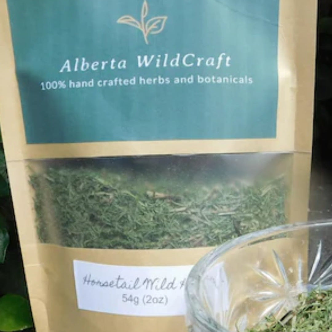 Bag of Alberta WildCraft herbs with a glass container of dried herbs on a dark surface.